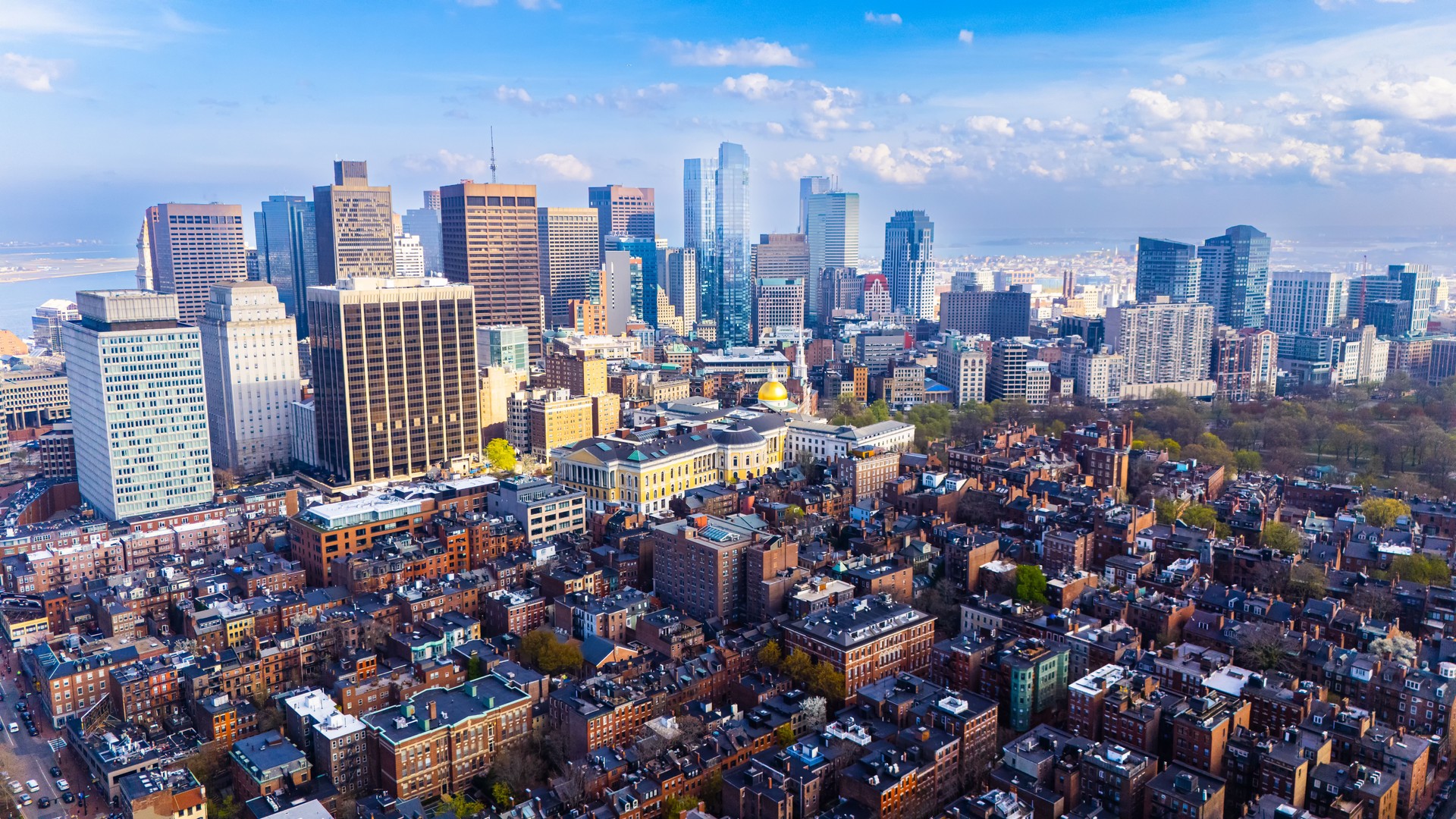 Orange brick houses along stunning skyscrapers. Varied scenery of Boston, Massachusetts, USA. Aerial view.